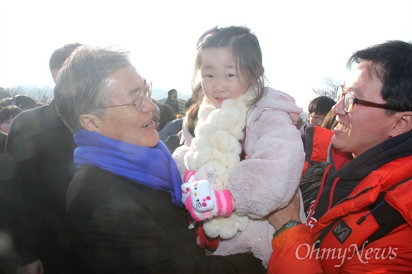 1일 오후 고 노무현 전 대통령 묘역 신년참배를 위해 김해 봉하마을을 찾은 문재인 더불어민주당 대표가 한 아이를 들어보이며 웃고 있다.