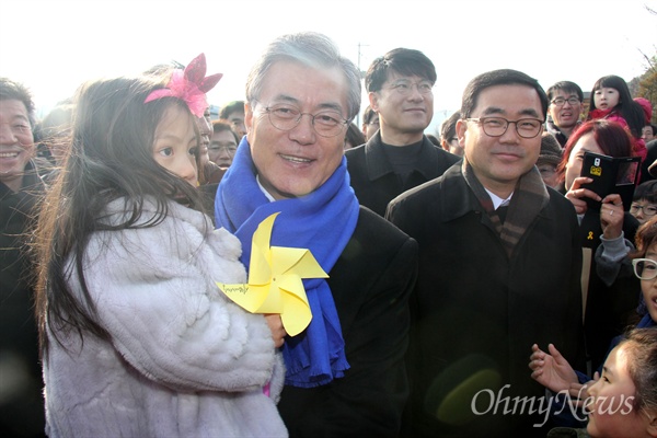 1일 오후 고 노무현 전 대통령 묘역 신년참배를 위해 김해 봉하마을을 찾은 문재인 더불어민주당 대표가 한 아이를 들어보이며 웃고 있다.
