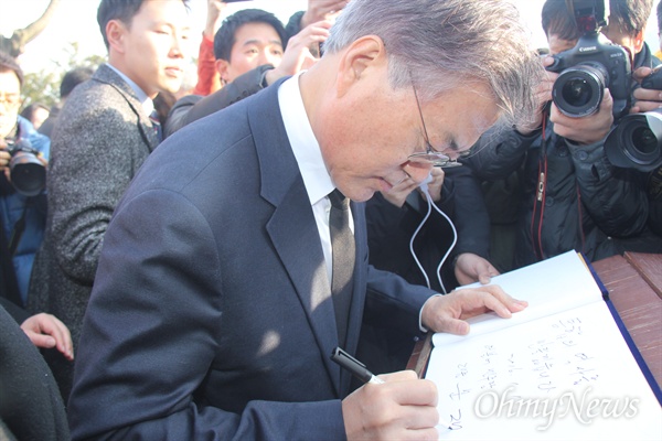 1일 오후 김해 봉하마을 고 노무현 전 대통령 묘역을 참배한 더불어민주당 문재인 대표가 방명록에 서명하고 있다.