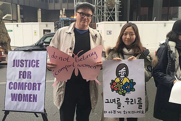 지난 6일 영국 런던 주재 한국대사관 앞에서 열린 수요집회에 참석자들이 위안부 문제 해결을 촉구하는 문구를 들고 있다. 
