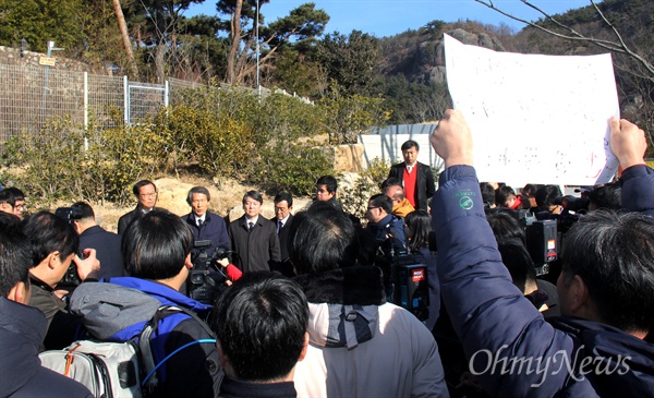  국민의당 창당준비위 한상진 공동위원장과 안철수 의원 등이 12일 오전 경남 김해 고 노무현 전 대통령 묘역을 참배하고 사저에 들렀다가 나온 뒤 기자들 앞에서 브리핑을 하는 동안, 김해시민 이아무개(53)씨가 "친노 패권주의 낡은 진보라매? 아직도 간 덜 봤냐?"고 쓴 손팻말을 들고 서 있다.