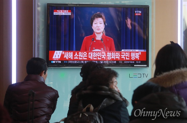 13일 오전 서울 용산구 서울역 대합실에서 시민들이 TV 모니터를 통해 박근혜 대통령 대국민담화 발표 생중계를 지켜보고 있다.  
