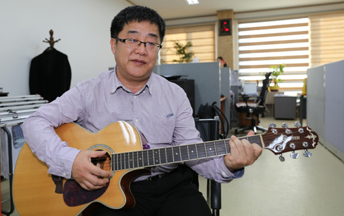 박철환 씨가 기타로 자신이 만든 노래 '동지'를 연주해 보이고 있다. 지난 6일 나주신문 사무실에서다.