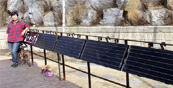 방송인 김미화씨가 자신이 운영하는 호미카페에 설치한 태양광 미니 발전소 앞에서 포즈를 취하고 있다.