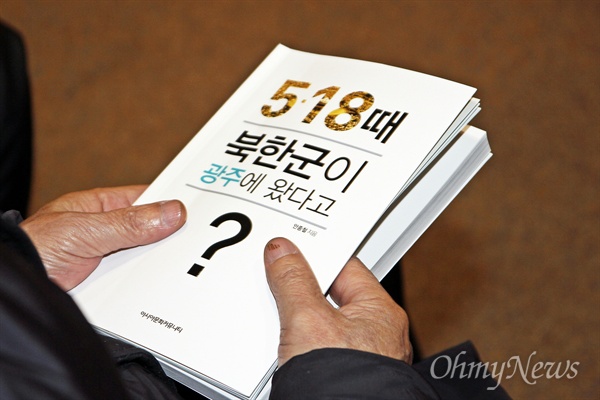 25일 <5.18 때 북한군이 광주에 왔다고?> 출판을 기념하기 위한 '대동한마당 및 저자 사인회'에 참석한 한 시민이 책 한 권을 손에 쥐고 있다.