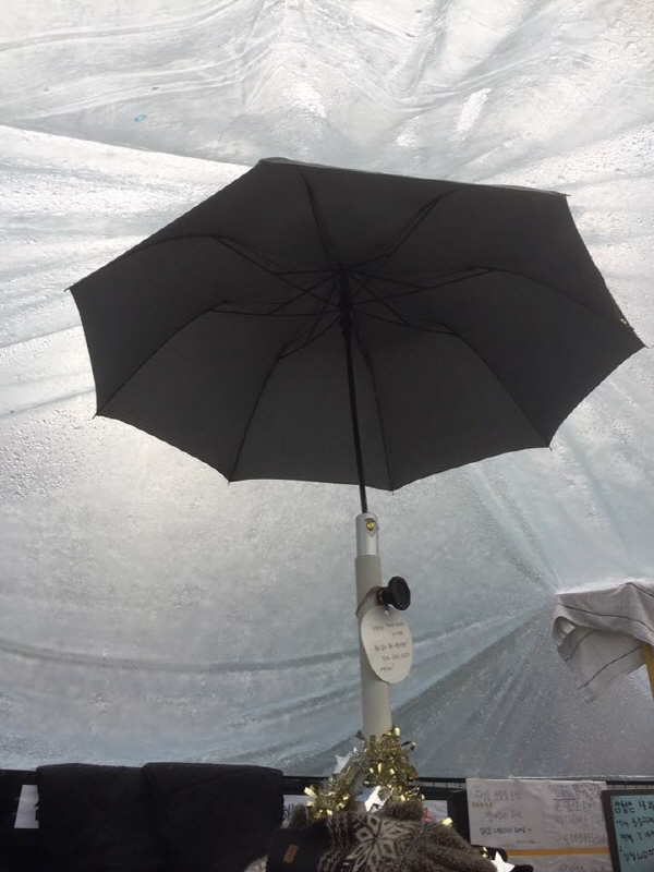 반올림 농성장을 우산 하나가 받치고 있다