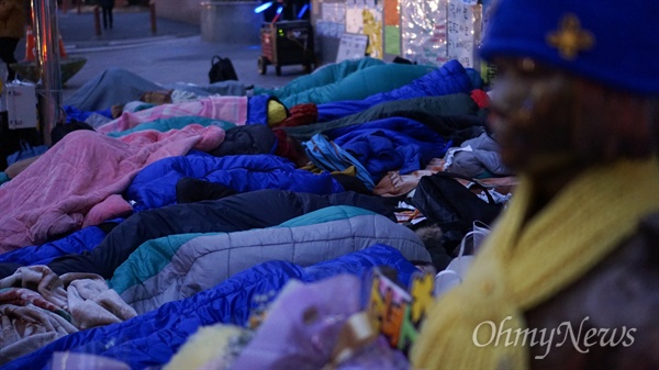 1월 28일 새벽 서울 종로구 평화의 소녀상 옆에서 대학생들이 침낭 속에 한뎃잠을 자고 있다.
