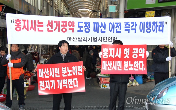  마산살리기범시민연합 회원들이 1일 오후 창원시 마산회원구 소재 동마산시장 앞에서 홍준표 지사를 비난하는 펼침막과 손팻말을 들고 서 있다.