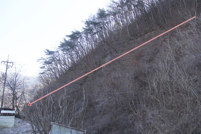  산 위쪽에서 마을 방향으로 본 임도 개설 예정구간(붉은 선 부분). 아래로 하천이 흐르고 있다.