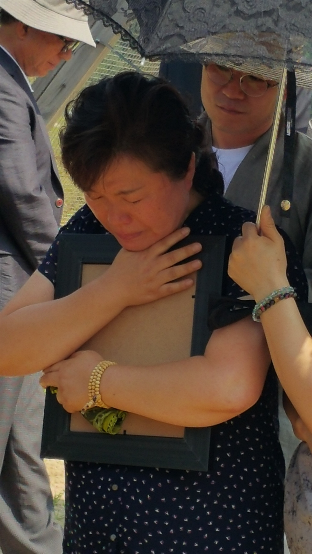 윤영준 이병의 안장식이 열린 2015년 8월 6일. 윤 이병의 어머니가 아들의 영정 사진을 가슴에 품은 채 마지막 작별을 고하고 있다.