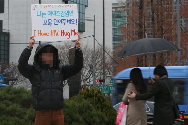세계 에이즈의 날(12월1일)을 하루 앞둔 지난 2014년 11월 30일 오후 서울 보신각 앞에서 한 시민이 '나는 에이즈 감염인, 꼭 안아주세요'라고 적힌 팻말을 든 채 프리허그를 요청하고 있다. 