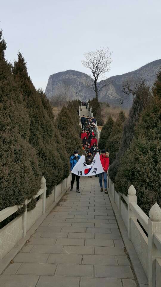 석정 윤세주열사와 진광화열사가 안장되었던 연화산 석문촌의 초장지로 밀양시 석정의 생가에서 가지고 간 흙을 기념관에 안치하기 위해 대학생들이 태극기를 앞세우고 묘역에서 기념관으로 의식을 진행하고 있다