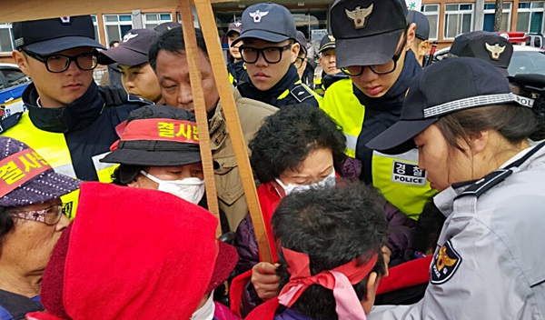 경찰이 군수 면담을 요구하며 군수실로 향하는 주민들과 실랑이를 벌이고 있다.