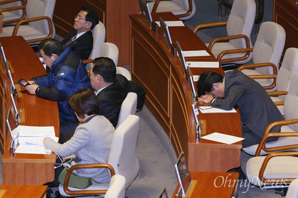 24일 새벽 국회 본회의장에서 은수미 더불어민주당 의원의 테러방지법 반대 무제한 토론(필리버스터)이 이어지고 있는 가운데 본회의에 참석한 일부 의원들이 졸음을 참지 못하고 엎드려 있다.