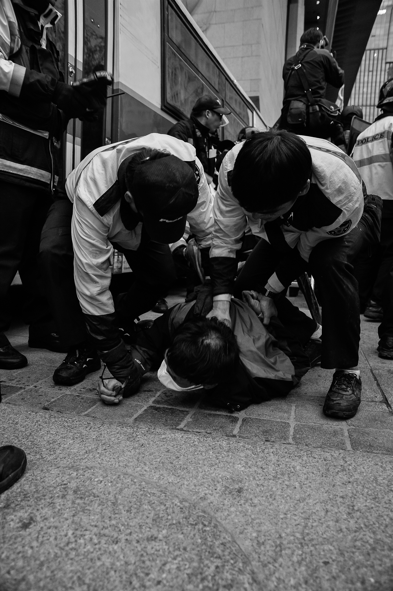 광화문 부근에서 경찰이 한 참가자의 목을 눌러 강제로 연행하고 있다.