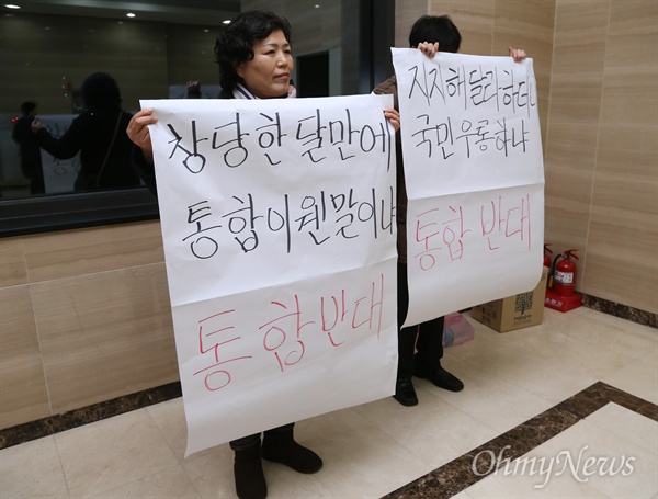 4일 오후 서울 마포 국민의당 당사 입구에서 야권통합에 반대하는 당원들이 '통합 반대' 피켓을 들고 있다. 