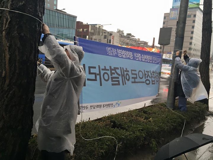 서울역 광장 시민평화행동 참가자들이 현수막을 부착하고 있다