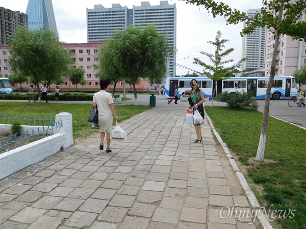 안내원 김혜영 선생(왼쪽)과 함께 설경이네 아파트로 향하는 모습. 사진 왼쪽 중간에 설경이 부부가 의성이를 데리고 걸어오는 모습이 보인다.
