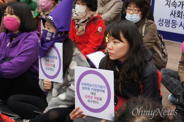세계여성의날 기념 대구여성대회가 8일 오후 대구시 중구 동성로 대구백화점 앞에서 열린 가운데 참가자들이 자신들의 요구를 담은 피켓을 들고 앉아 있다.