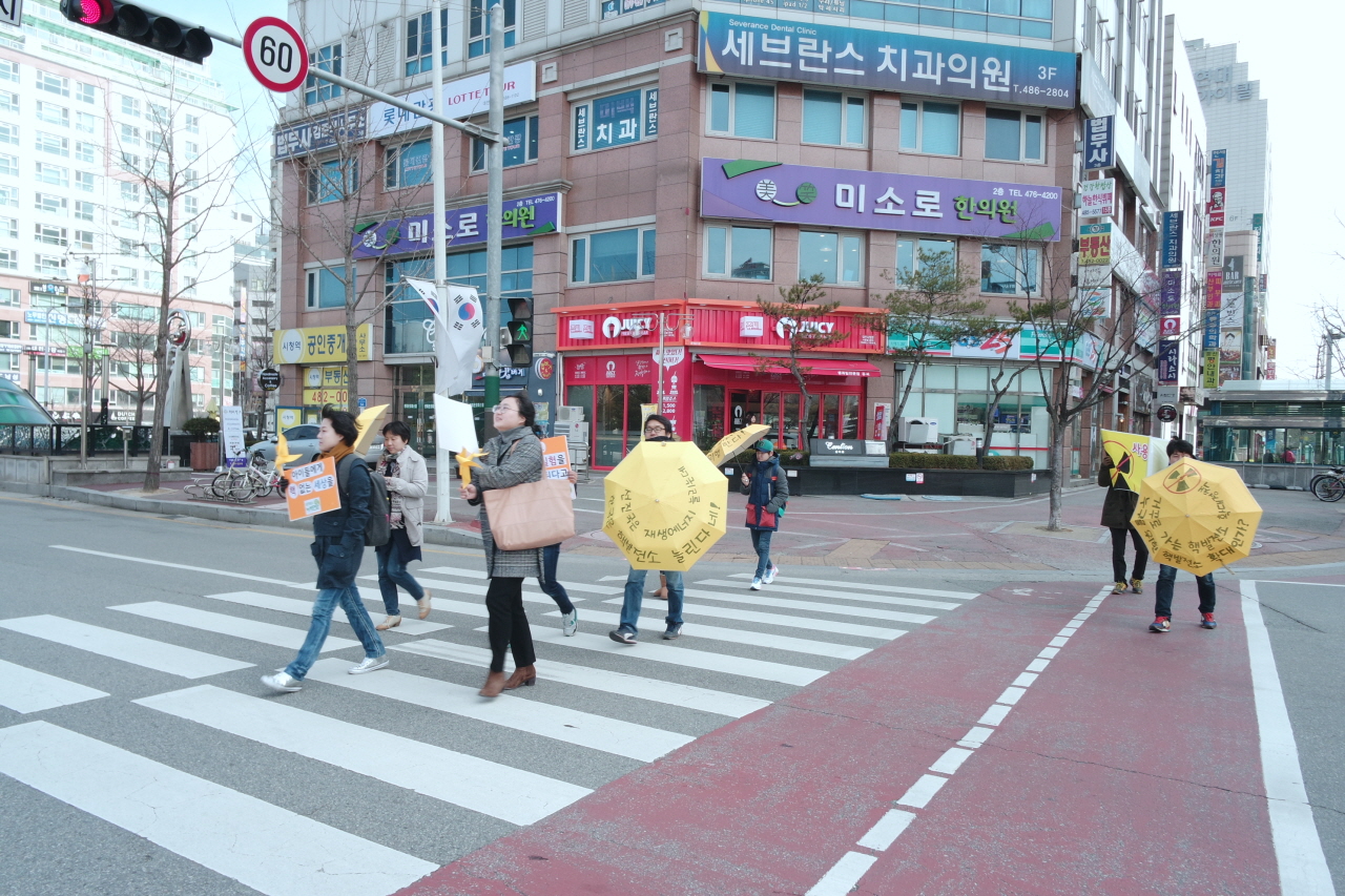 도보캠페인 우산과 피켓을 들고 거리를 이동하며 캠페인을 벌이고 있다. 