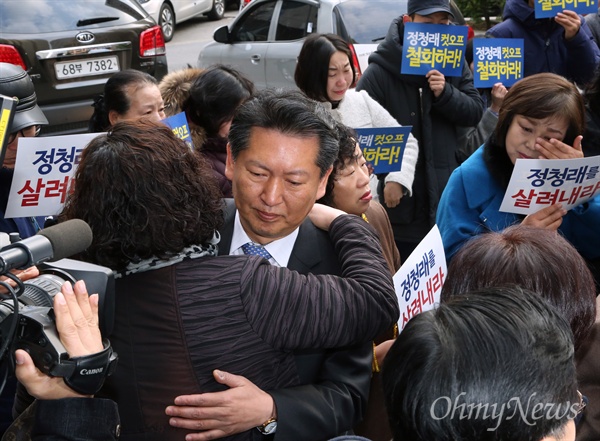 더불어민주당 공천에서 배제된 정청래 의원이 12일 재심을 신청하기 위해 서울 여의도 당사 앞에 도착해 정 의원의 공천배제 철회를 요구하는 지지자들과 포옹하고 있다. 