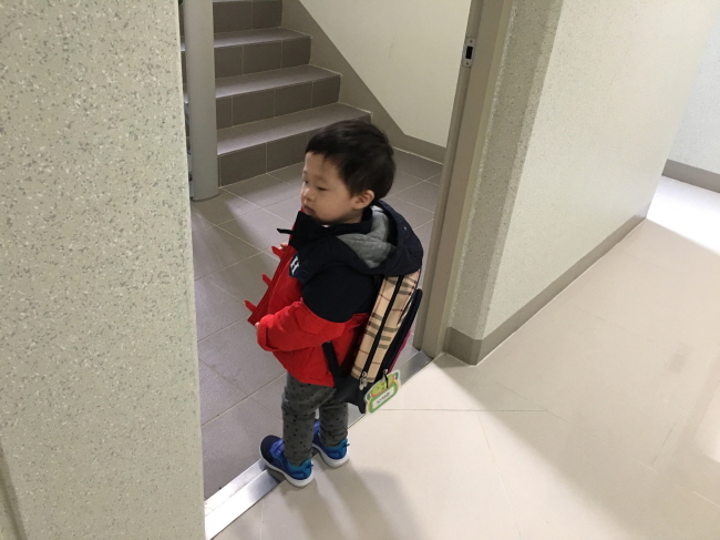 자기 등짝 만한 어린이집 가방을 둘러메고 어린이집으로 향하여 아파트를 나서고 있는 서준이의 늠름한 모습입니다.
