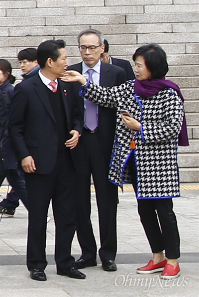  지난 3월 3일 오전 국회 앞에서 진행된 더불어민주당 '달리는 정책의자' 발대식에 손혜원 홍보위원장이 정청래 의원 옷에 묻은 먼지를 털어주고 있다.