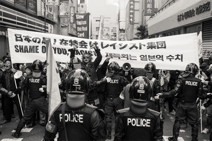 혐한 시위에 저항하는 카운터스의 모습. "재특회는 일본의 수치"라는 현수막을 들고 있다. 