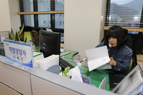  이혜진 씨가 구직자와 전화 상담을 하며 관련 서류를 뒤적이고 있다. 이 씨는 하루 평균 30∼40명과 상담을 한다.