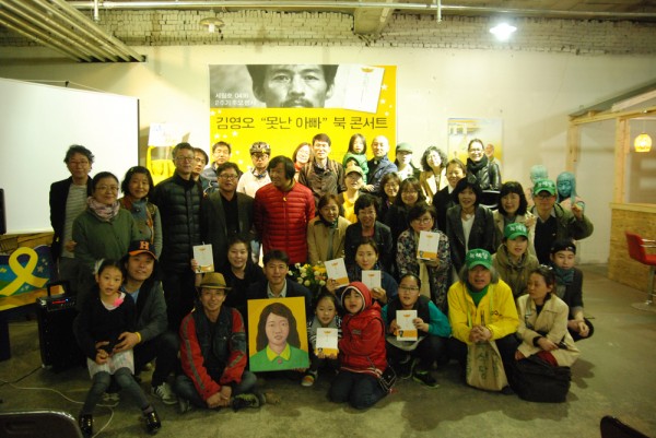 북콘서트 참가자와 단체사진을 찍는 ‘유민아빠’ 김영오씨. 가운데 그림을 든 이.