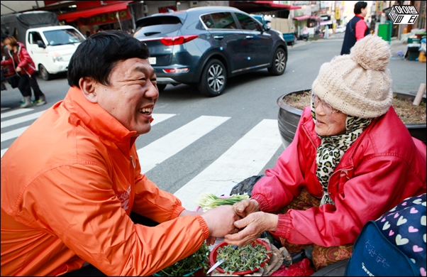 울산 동구에 출마한 무소속 김종훈 후보가 동울산시장에서 나물을 파는 할머니와 손을 잡고 얘기를 나누고 있다.