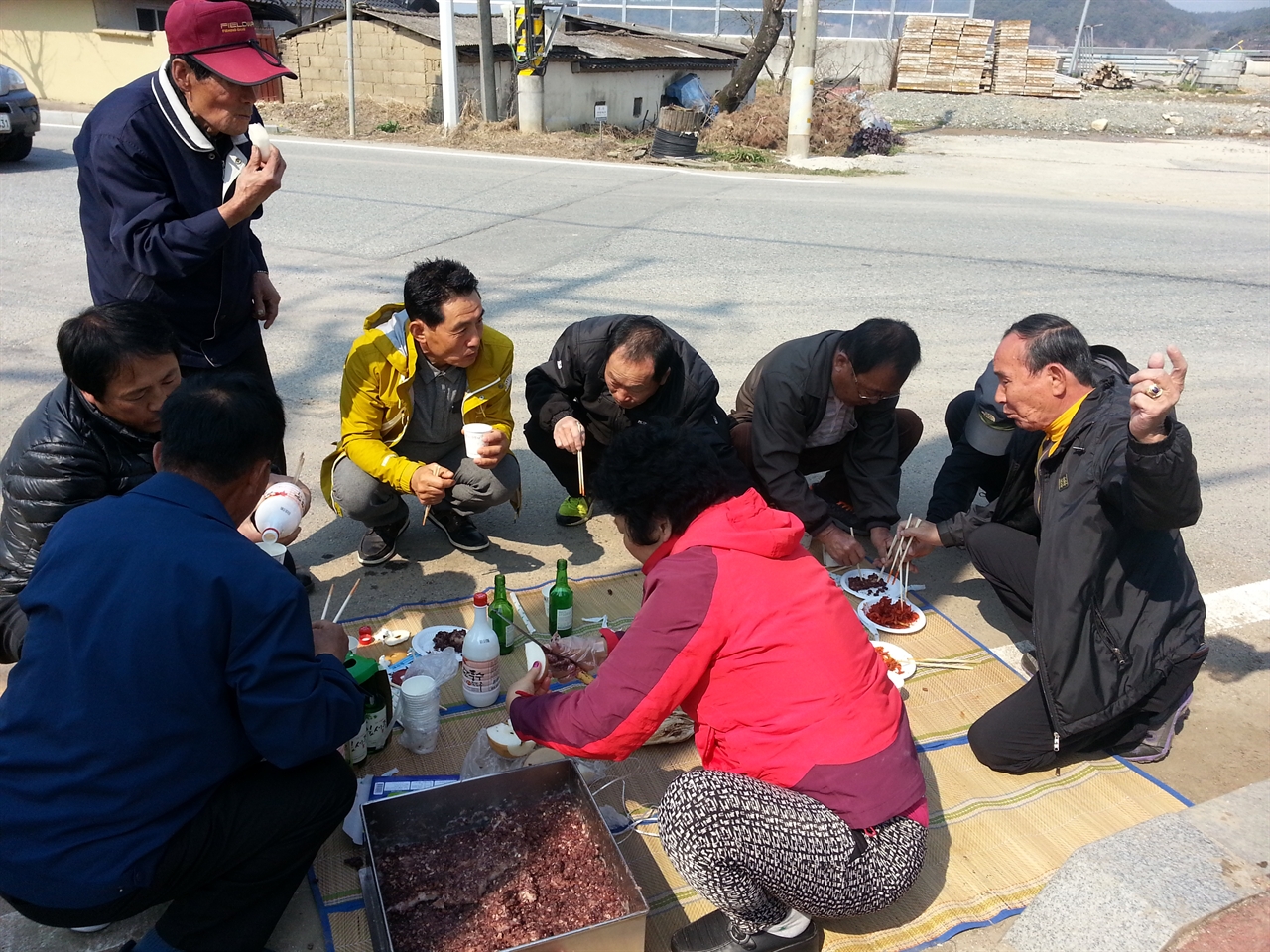 구산동 주민들이 덕담을 주고 받으며 음식을 나누고 있다.