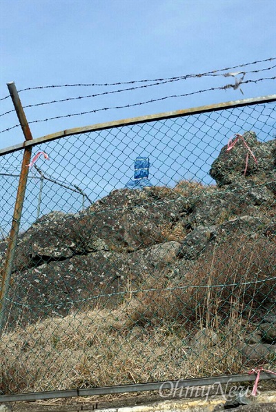 창원-김해에 걸쳐 있는 불모산 정상 부근에 표지석이 있는데, 군부대의 철조망 안에 있다. 군부대가 등산객들이 사진을 찍을 수 없도록 표지석에 천막을 씌워 밧줄로 감아놓았다.