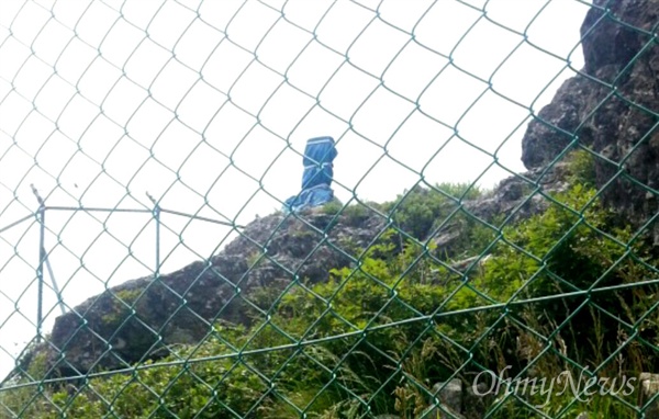 창원-김해에 걸쳐 있는 불모산 정상 부근에 표지석이 있는데, 군부대의 철조망 안에 있다. 군부대가 등산객들이 사진을 찍을 수 없도록 표지석에 천막을 씌워 밧줄로 감아놓았다.