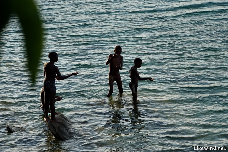  아이들은 물가에서 뛰어 놀고, 어른들은 작은 배를 타고 호수에서 낚시를 한다.