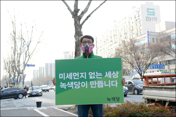변홍철 녹색당 국회의원 후보(대구 달서갑)가 초미세먼지를 없애겠다는 공약을 내놓고 산소마스크를 쓴 채 피켓을 들고 서 있다.