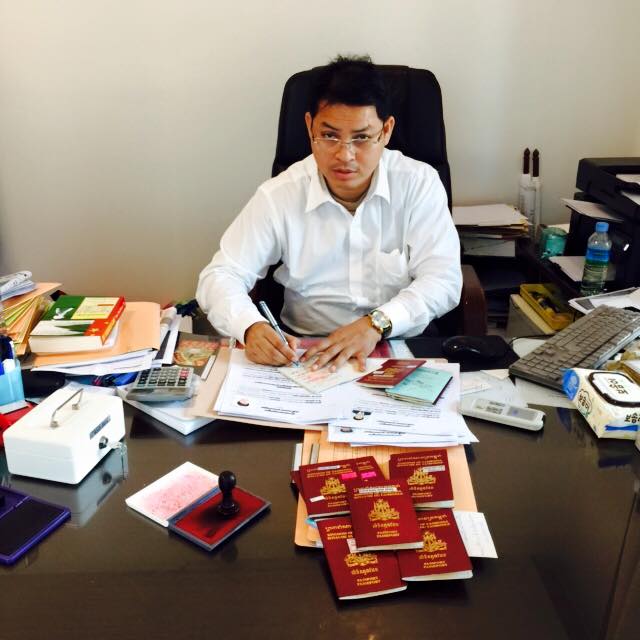 캄보디아 자국국민들의 여권에 기간 연장을 위한 서명을 하고 있는 숫 디나 주한 캄보디아 대사의 모습