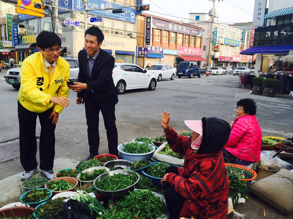  전통김제시장 사거리에서 강상구 정의당 전북 김제·부안 후보가 상인과 대화를 나누고  있다. 상인이 손으로 강 후보의 번호인 '4번'을 그려 보이고 있다. 