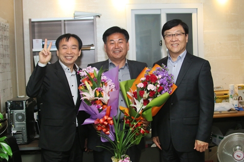 논산시의회 김헌익 사무국장(우측)이 김만중 시의원 당선자에게 축하 꽃다발을 전달하고 있다