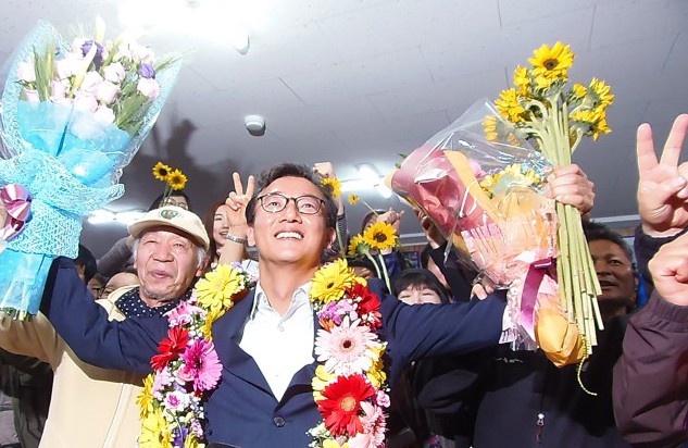 부산 북강서갑 전재수(더불어민주당) 당선자가 북구 구포동 캠프에서 지지자들이 "전재수~ 전재수~"을 연호하고 있다. 전 후보는 이날(13일 저녁) 캠프를 방문한 지지자들에게 나눠줄 해바라기와 축하꽃다발을 들고 있다.