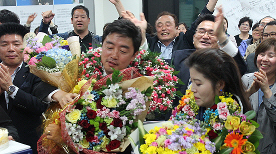더불어 민주당 강훈식 후보와 부인인 방송인 김희경씨가 당선이 확정되자 지지자들이 꽃다발을 건네며 축하해주고 있다. 