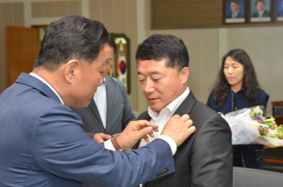 유기준 의장이 재선거에 당선된 여운영 의원에게 배지를 달아주고 있다.
