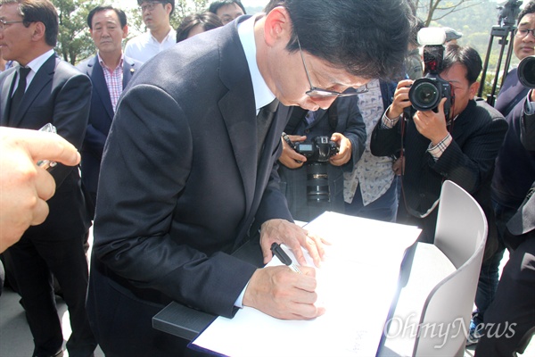 김해을 국회의원선거 김경수 당선인이 14일 오전 봉하마을 고 노무현 전 대통령 묘역을 참배하고 나오면서 방명록에 서명하고 있다.