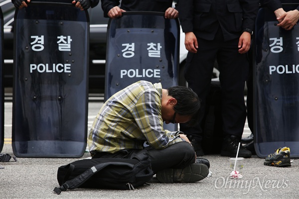 세월호참사 범국민철야행동 이틀째인 2015년 5월 2일 오전 서울 안국동네거리에서 유가족들과 경찰이 밤샘 대치하는 가운데 세월호가족대책위 법률대리인인 박주민 변호사가 앉은 채로 잠들어 있다.