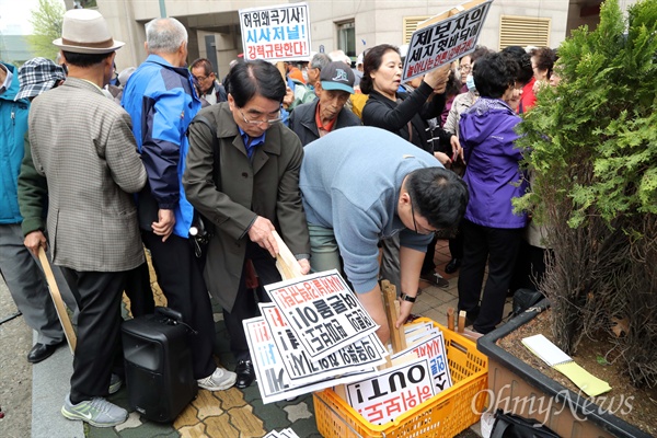 피켓 반납하는 대한민국어버이연합 회원들 대한민국어버이연합(이하 어버이연합) 회원들이 21일 오후 서울 용산 주간지 <시사저널> 앞에서 청와대의 지시로 보수단체 집회를 개최했다고 보도한 <시사저널>을 규탄하는 기자회견에 참석한 뒤 관계자에게 피켓을 반납하고 있다.