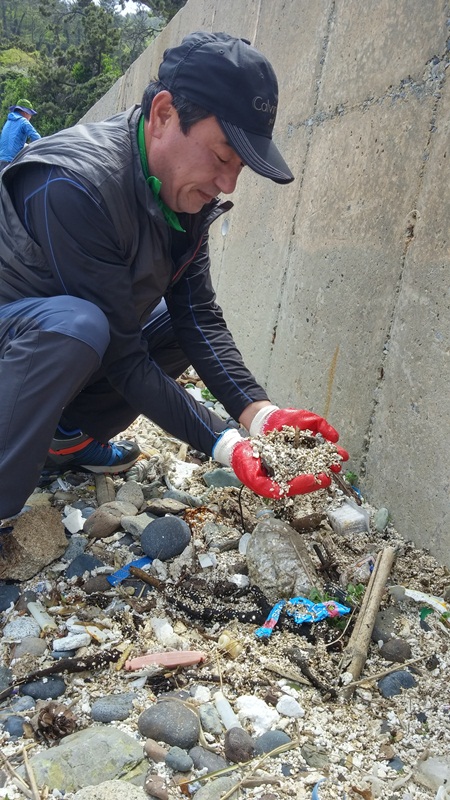 여수환경운동연합 천상국 회원이 의성리 바닷가에서 스티로폼 조각들을 파헤치고 있다.떠밀려온 스치로폼들이 부숴져 이곳에 쌓여있다. 
