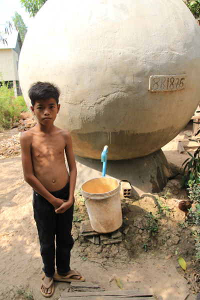 캄보디아 남부 다께오 지방 한 시골마을 소년이 마을에 설치된 빗물저장탱크에서 식수를 받고 있다. 