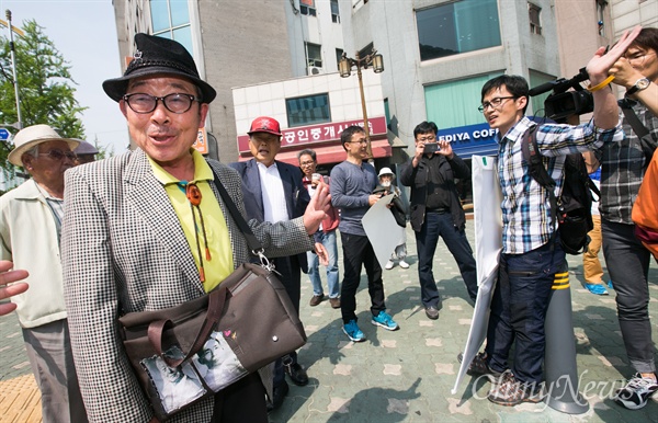 1인 시위 비난하는 어버이연합 회원들 인터넷 닉네임 '둥글이'로 알려진 박성수씨가 29일 오후 서울 종로구 어버이연합 사무실 앞에서 청와대의 어버이연합 관제데모 지시 의혹 및 1인시위방해 등을 규탄하며 '어버이연합 해체'를 촉구하하는 1인 시위를 하고 있다. 이를 본 어버이연합 회원들이 항의를 하고 있다.