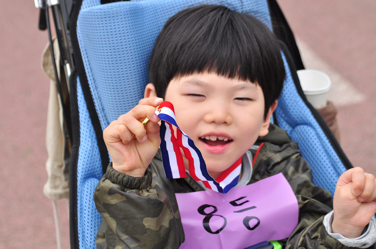 메달을 들고 기뻐하는 박건우 어린이