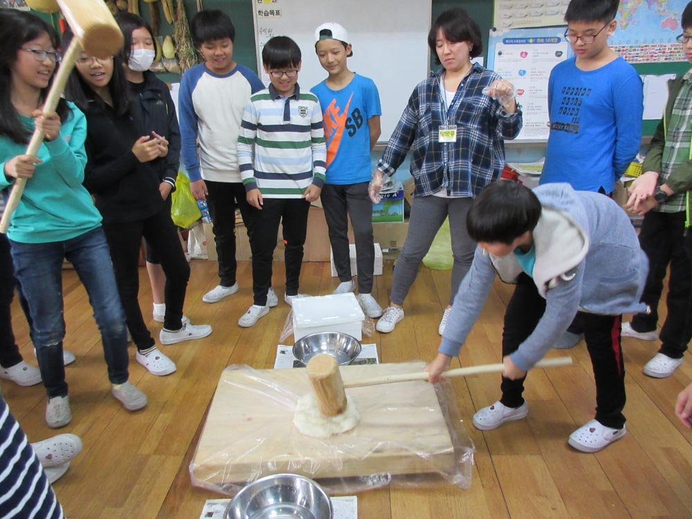  서울신북초등학교 학생들이 상자텃밭에서 수확한 쌀로 인절미를 만들기 위해 떡메를 치고 있다.